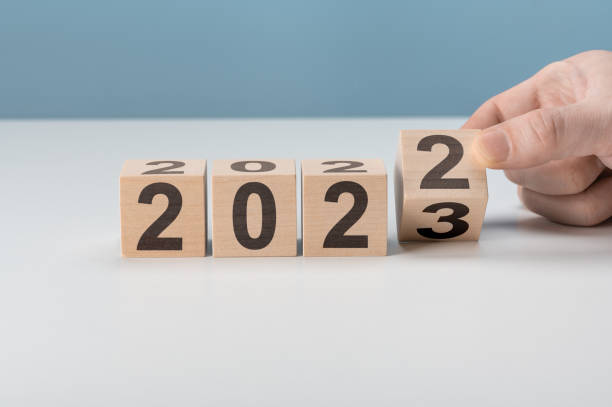 happy 2023 neujahrskonzept, flipping von holzwürfelblock wechsel von 2022 auf 2023. starten sie das neue jahr 2023 mit zielplan, zielkonzept, aktionsplan, strategie, neujahrs-geschäftsvision. - einladungskarte grafiken stock-fotos und bilder