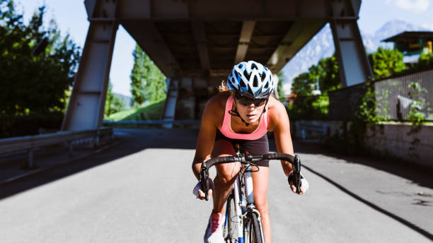 レーシングバイクでスプリントトレーニング中の女性サイクリスト - cycling bicycle bicycle gear triathlon ストックフォトと画像