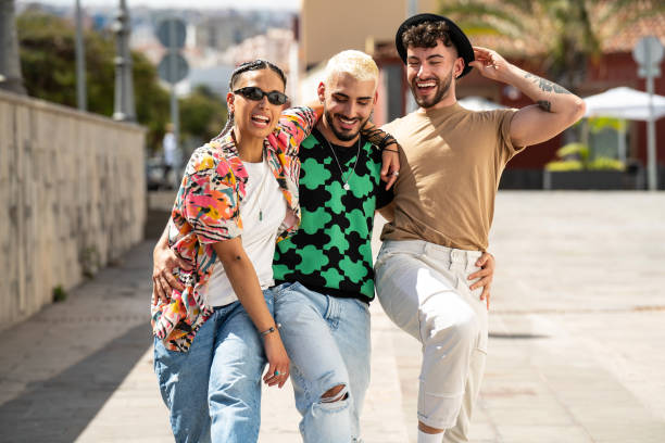 trois jeunes gens heureux qui se promènent dans la ville, se parlent, rient et s’amusent. groupe d’amis multiethniques. - candid talking beautiful casual photos et images de collection