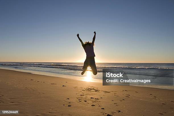 Man Jumping High Up At The Beach During Sunrise Stock Photo - Download Image Now - 20-29 Years, Active Lifestyle, Activity