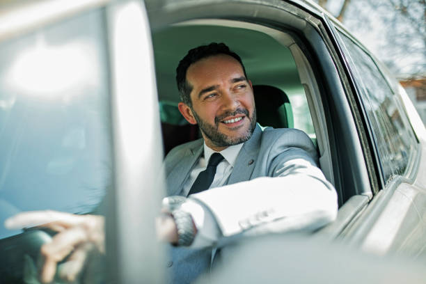 istock Smiling businessman driving to office 1395345731