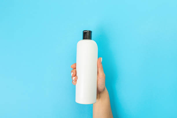 istock Housewife's hand holds a spray with cleaning agent on a blue background. Detergent for various surfaces in the kitchen, bathroom and other rooms. Close-up. Light pastel blue background. 1395346019