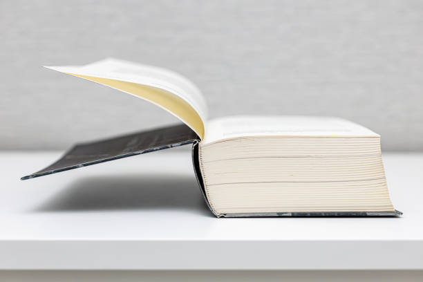 istock a thick book in an open form lies on a white table 1395346136