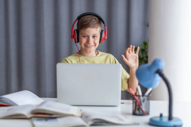 istock Happy student greeting someone during an online class over laptop at home. 1395346234