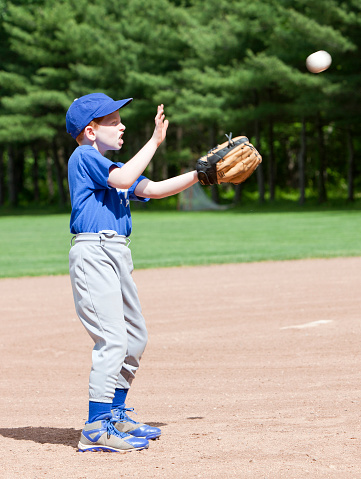 Young boy baseball player catching a ball