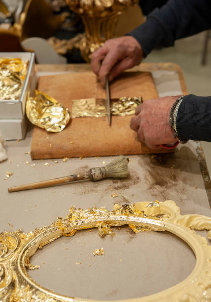istock Application of gold leaf to a frame. Gilding process technique. 1395350533