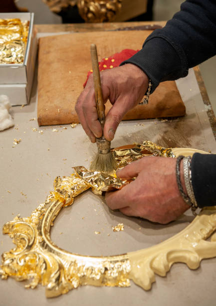 istock Application of gold leaf to a frame. Gilding process technique. 1395350873