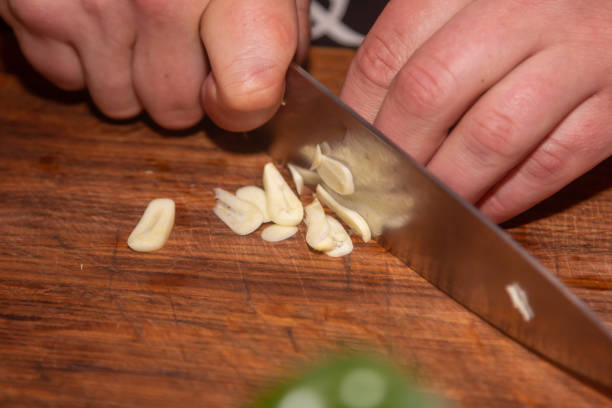 istock Chef slicing garlic on the cutting board with a knife 1395350931
