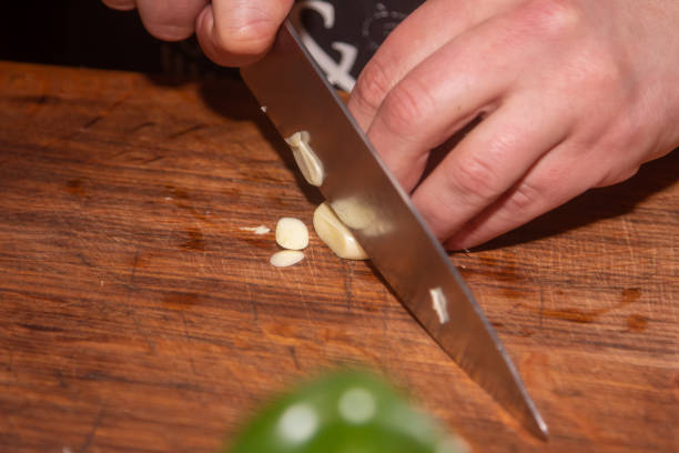 istock Chef slicing garlic on the cutting board with a knife 1395351259
