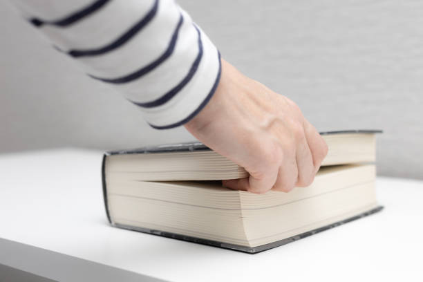 istock a woman's hand is between the pages of a book 1395352170