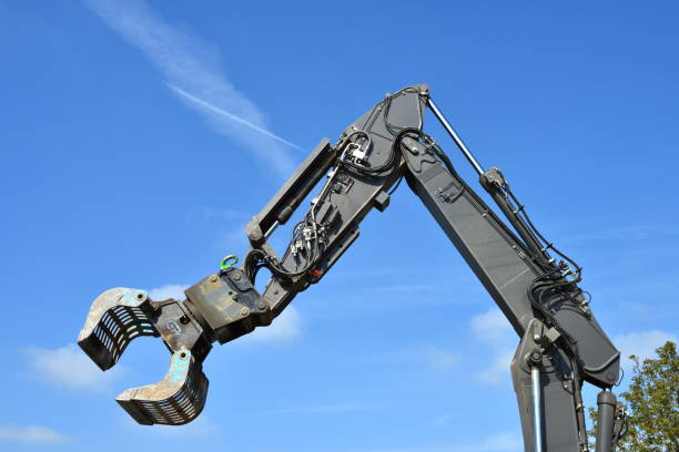 Wilsele, Vlaams-Brabant, Belgium - May 4, 2022: Hydraulic arm Volvo excavator with bucket in front of a blue sky
