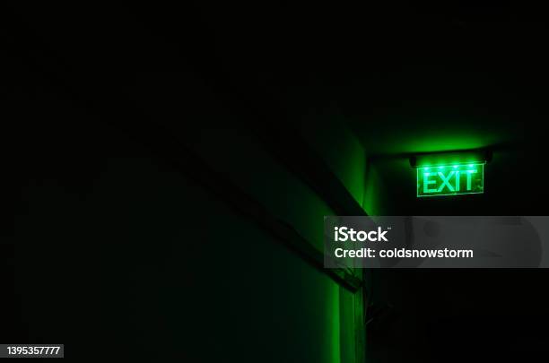 Neon Green Exit Sign Illuminated In Dark Corridor Stock Photo - Download Image Now - Exit Sign, Photography, Green Color