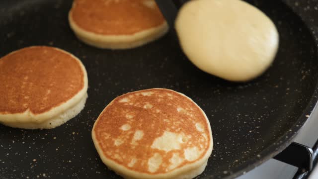 Flipping pancakes on a frying pan