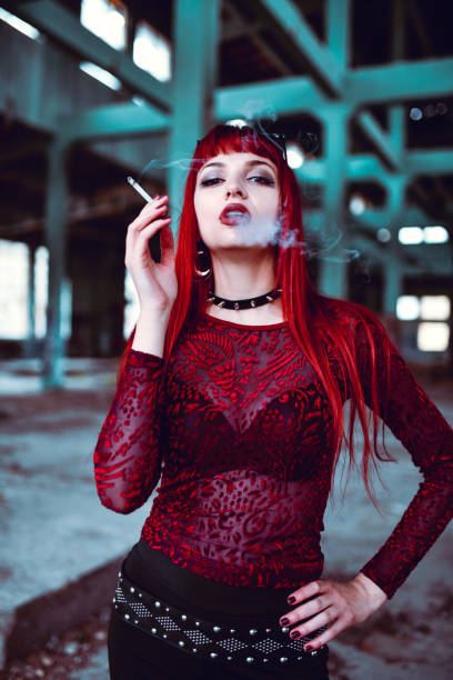 istock Beautiful Gothic Redhead Smoking Cigarette In Abandoned Building 1395360275