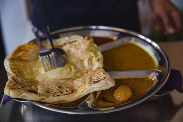Close-up shot of ready to eat Malaysian roti canai with curry sauce