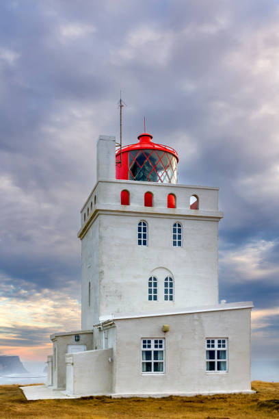 das alte leuchtturmgebäude in dyrhólaey an der südküste islands - atlantic coast flash stock-fotos und bilder