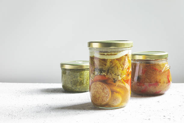Homemade canned meat on a gray table, the jars with farm organic canned food