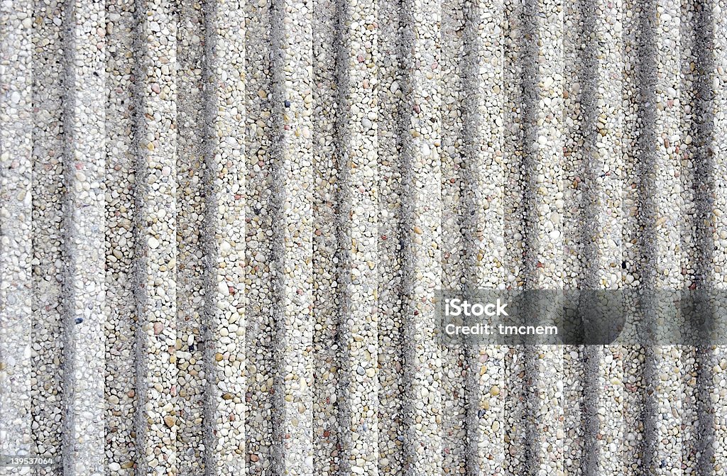 Fluted Concrete Background Closeup of a fluted concrete wall for background. Contains concrete and small stones embedded. Textured with flutes or grooves. Backgrounds Stock Photo