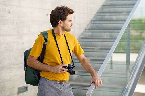 Millennial man using a SLR camera outdoors