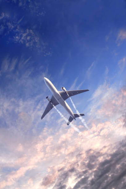 Fondo de naturaleza vertical con aviones y jet arrastrando humo en el cielo al atardecer. Avión y pista de condensación - foto de stock