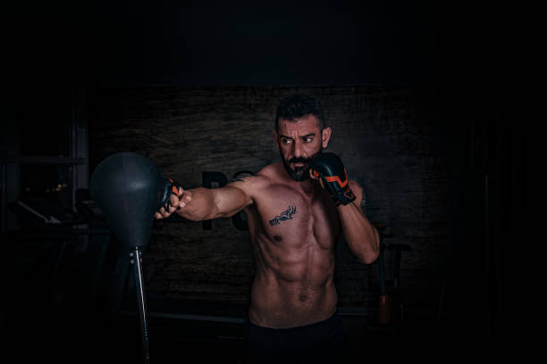 Concentrated young man box training in the gym