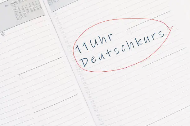 The words german course at 11 o´clock are standing in the german language in the calendar, education and integration concept
