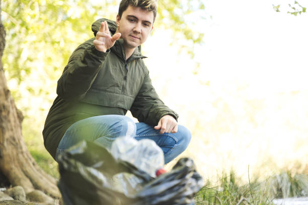 Homeless Male Poking Around Garbage Bags For His Belongings