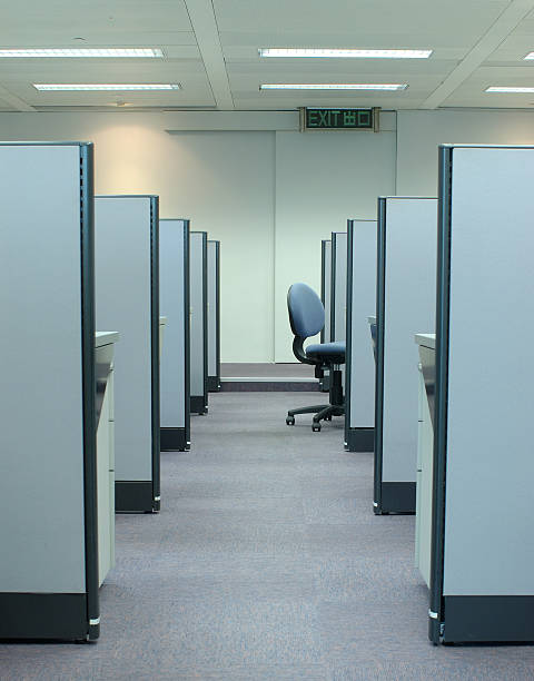 An empty chair alone between two cubicle rows stock photo