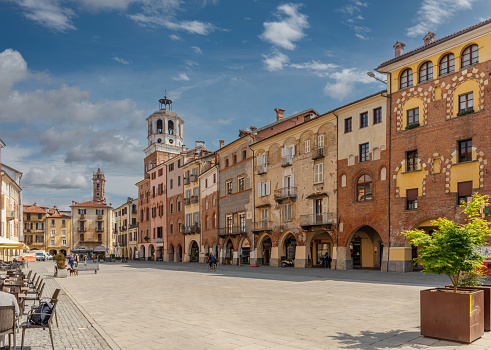 Savigliano, Cuneo, Piedmont, Italy - May 04, 2022: Piazza Santarosa with the civic tower, main square with historic buildings of medieval origin