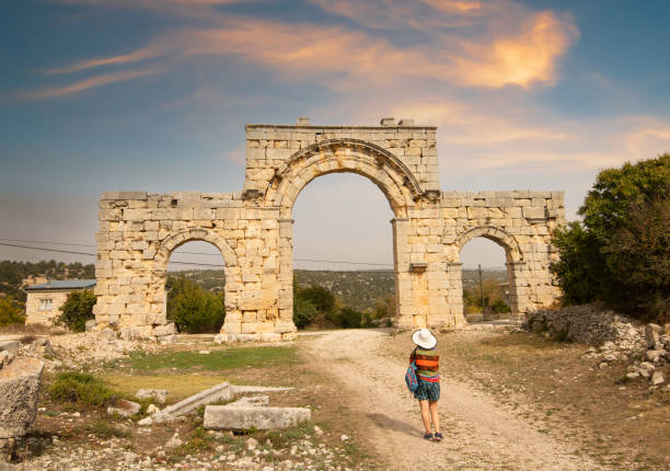 Marble City North Gate Marble City North Gate. Tourist girl in the ancient city. North entrance of ancient city of Uzuncaburc. Uzuncaburc antique city is in the rural area of Silifke district. Mersin, Turkey uzuncaburc stock pictures, royalty-free photos & images