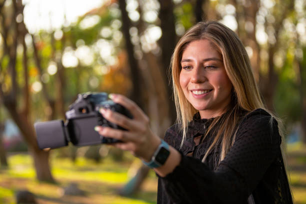 Executive woman taking a selfie with her DSLR.