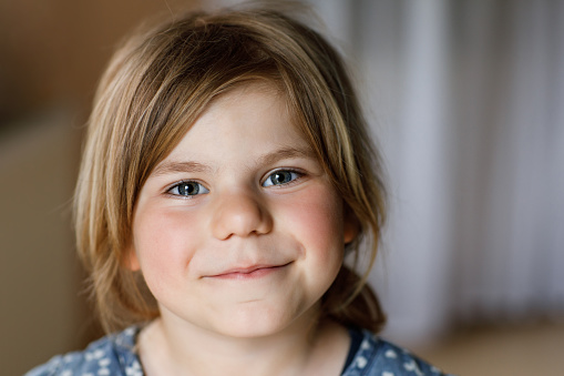 Close-up portrait of a cute little girl. Happy smiling preschool child looking at the camera. Childhood concept