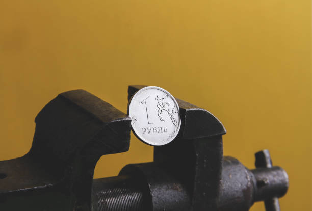 istock Coin in a vice. The collapse of the ruble. Blocking payment in rubles. 1395386895