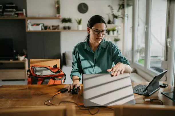 Businesswoman closing laptop computer after working at home alone.