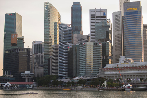 Singapore, June 14, 2019. Aerial view of the skyline of Singapore during a beautiful sunny day with the financial district in the distance. In front people are visiting the famous Merlion fountain at Marina Bay. Singapore is located in Southeast Asia.