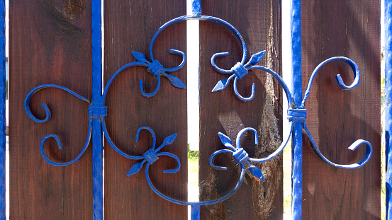 Blue window fence on wooden door.