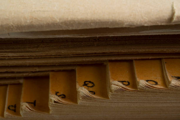 Old vintage withered English dictionary book with alphabet side view macro close up.