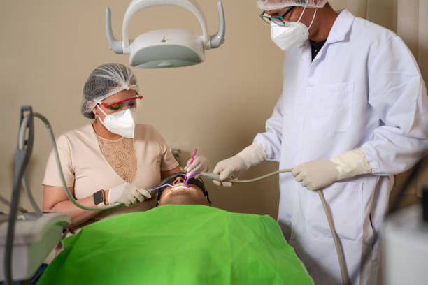 istock Dentist and assistant working with a patient in a dental clinic 1395391621