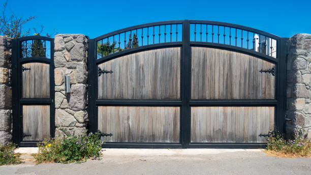 White gate and fence with pink roses on house entrance