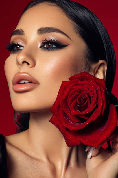 istock Beautiful woman holding red rose 1395397328