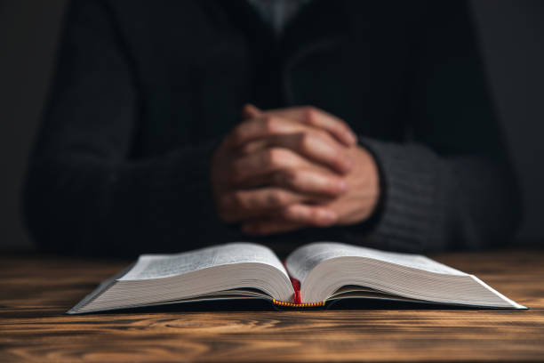 istock Hands of praying young man and Bible 1395399015