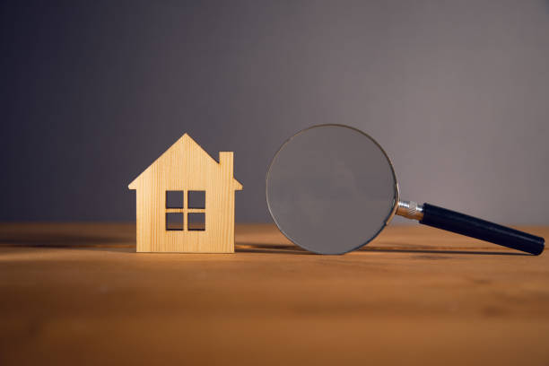 istock Wooden house and magnifying glass 1395399084