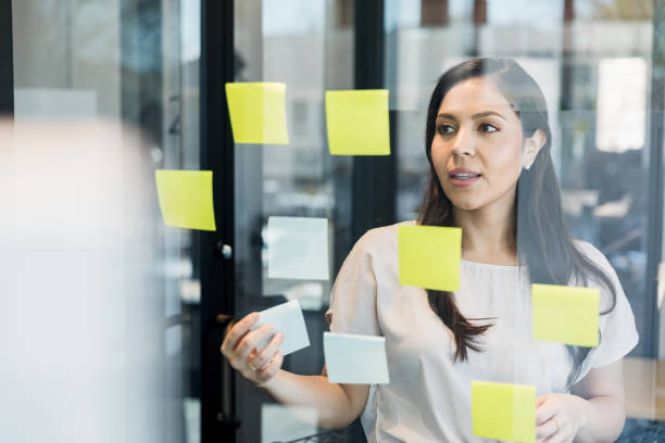 istock Company executive reviews her adhesive note system 1395400710