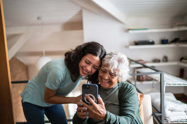 großmutter und enkelin benutzen das handy zu hause - photographing smart phone friendship photo messaging stock-fotos und bilder