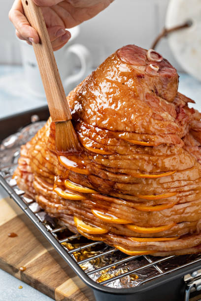 Making Easter or Christmas ham with honey orange glaze stock photo
