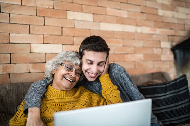 istock Grandson and grandmother using laptop at home 1395406500