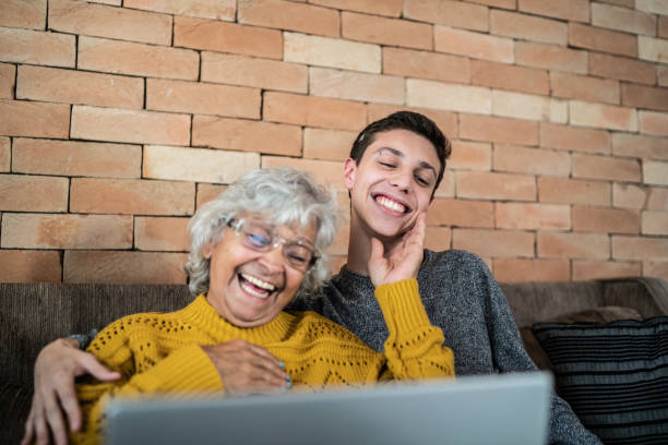 istock Grandson and grandmother using laptop at home 1395406518