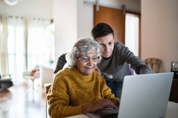 istock Grandson and grandmother using laptop at home 1395406527