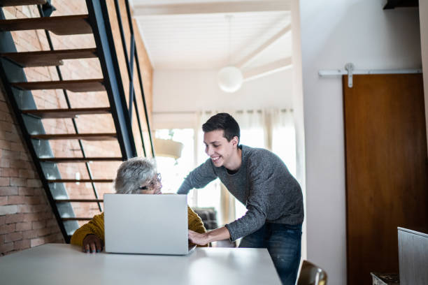 istock Grandson and grandmother using laptop at home 1395406536