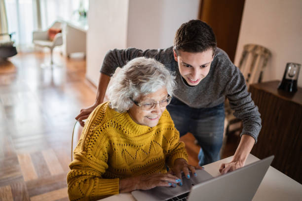 istock Grandson and grandmother using laptop at home 1395406574